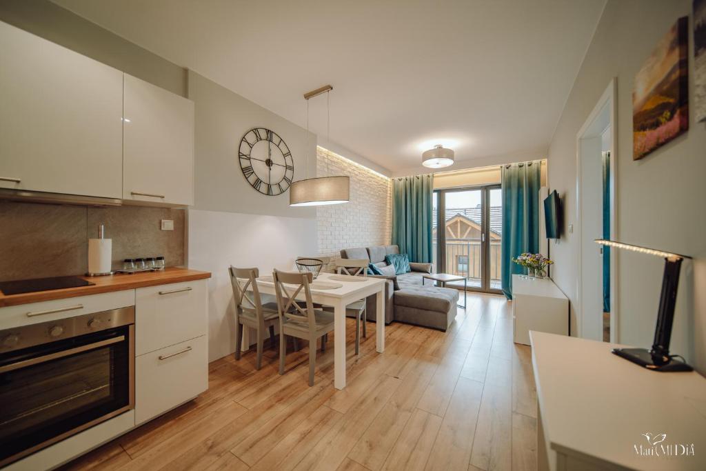 a kitchen and living room with a table and chairs at Apartament Silence Karpatia Resort Zelda in Karpacz
