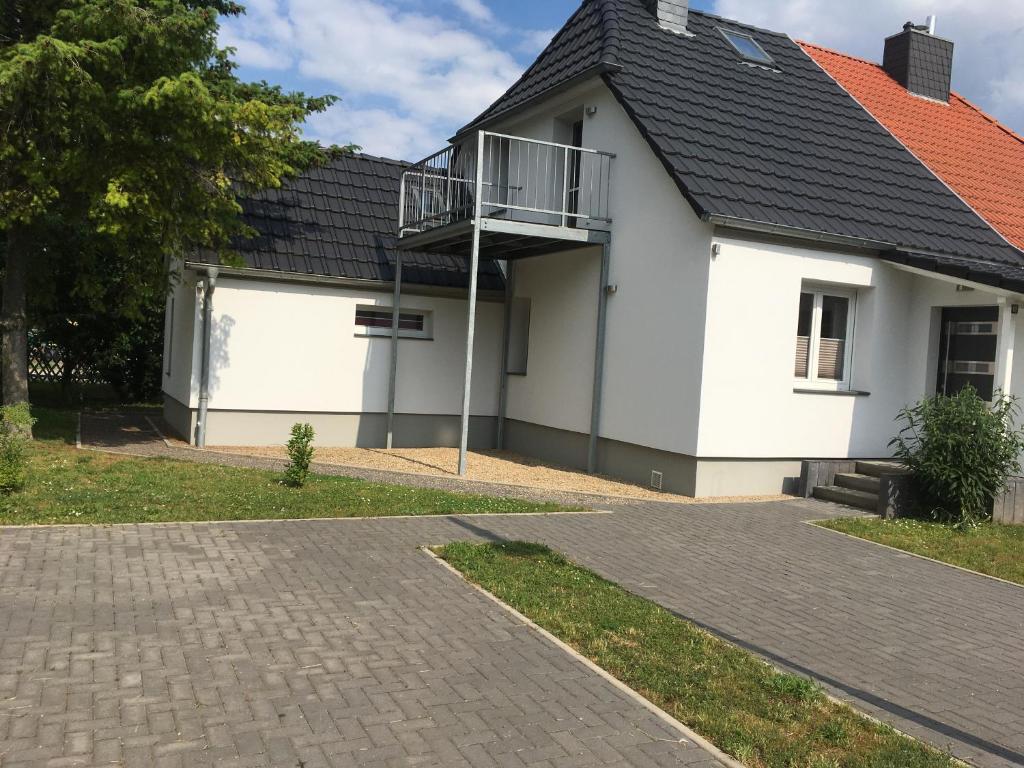 una casa blanca con techo negro en Ferienhaus am Geiseltalsee mit Sauna en Braunsbedra