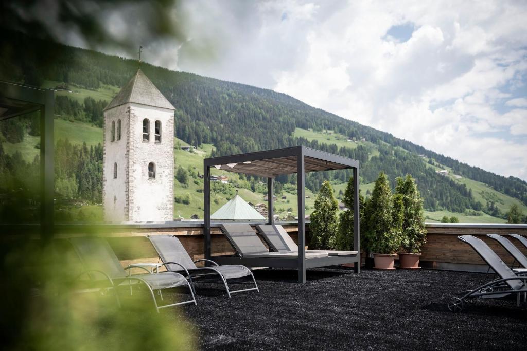 a group of chairs and a gazebo with a clock tower at Post Hotel - Tradition & Lifestyle Adults Only in San Candido