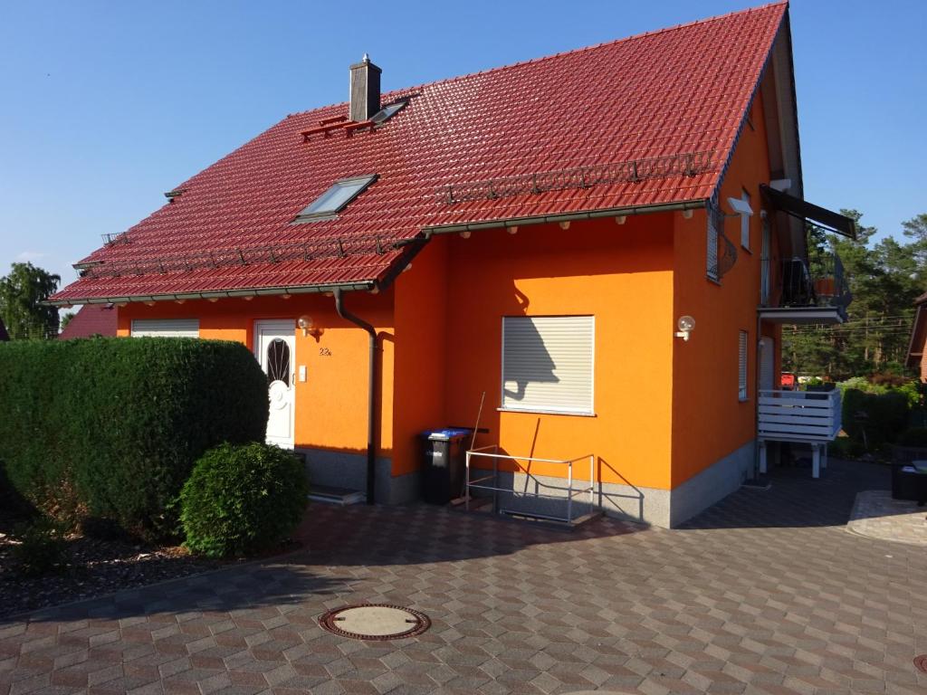 a small orange house with a red roof at Ferienwohnung Pfanne in Großkoschen