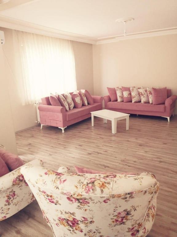 a living room with two pink couches and a table at Trabzon Meydan in Trabzon