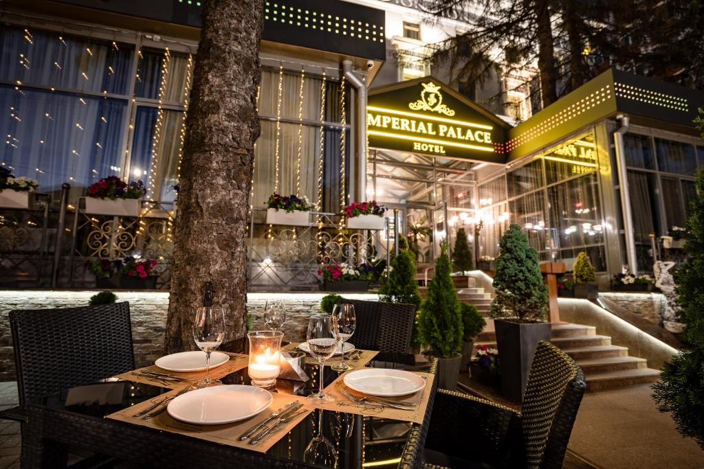 a table with plates and candles on top at Imperial Palace Hotel in Minsk