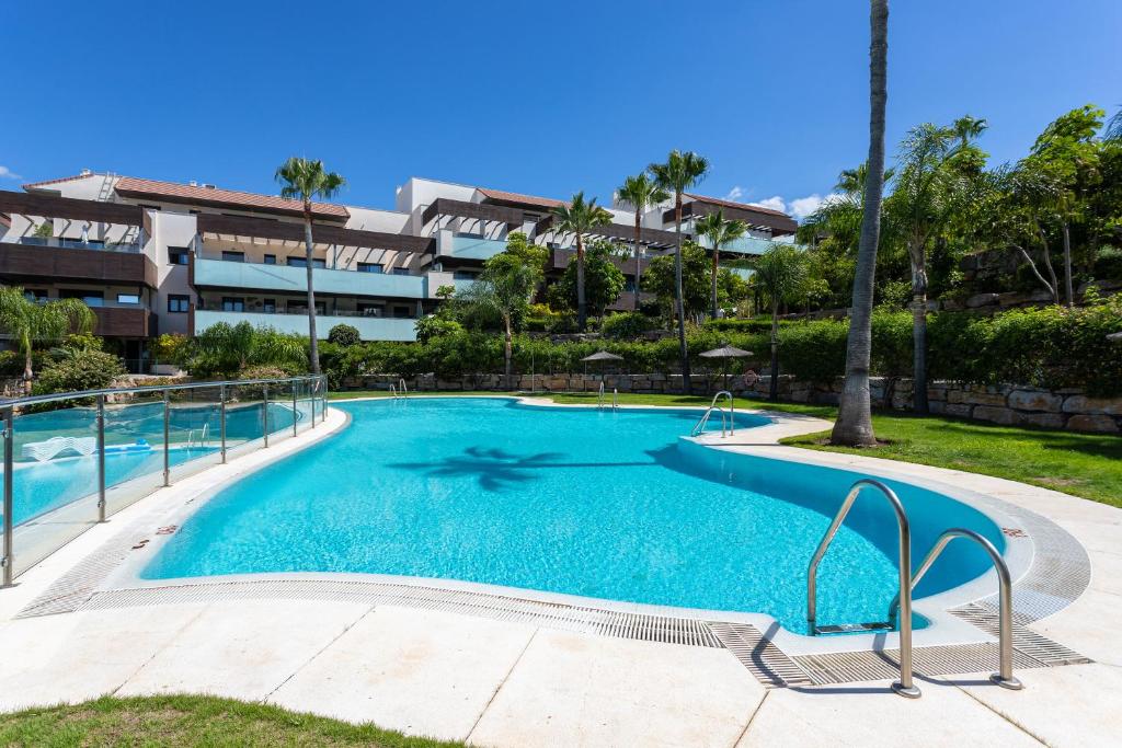 a large swimming pool in front of a building at Hoyo 19 Luxury Apartment by GHR Rentals in Estepona