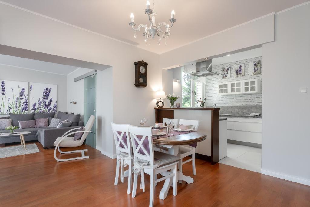 a kitchen and living room with a table and chairs at Lavender Cosy Apartment in Gdańsk