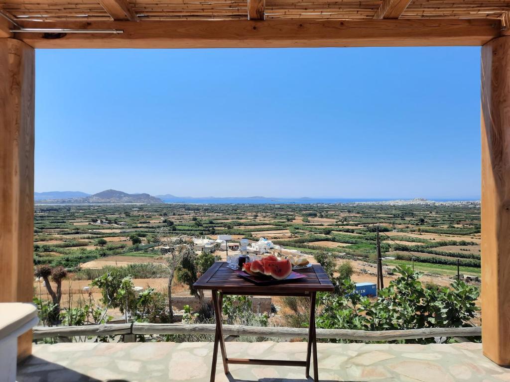 a table with a bowl of watermelon on a balcony with a view at Janakos View Apartment with Private Pool in Glinado Naxos