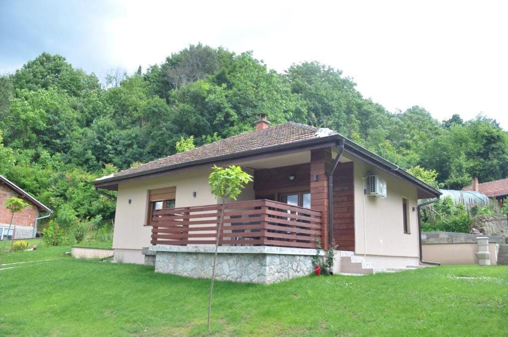 a small house with a deck in a yard at Babakaj in Golubac