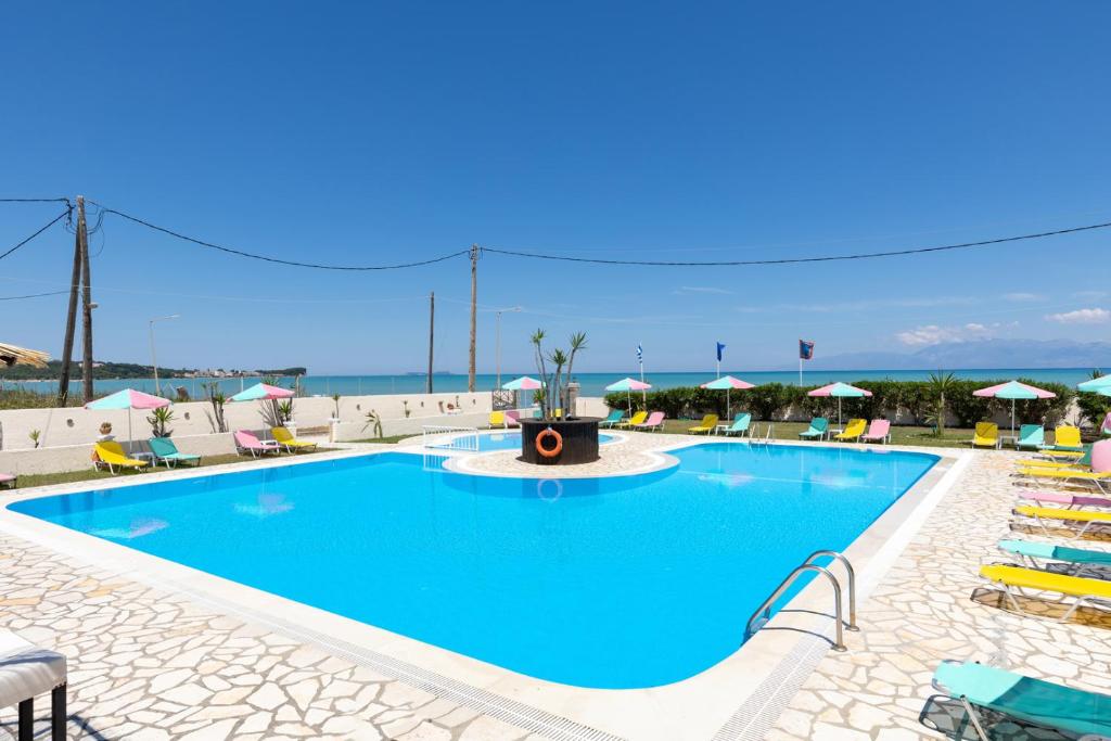 a large swimming pool with a fountain in front of the ocean at Amorossa Beachfront Village by Konnect, Roda Corfu in Roda