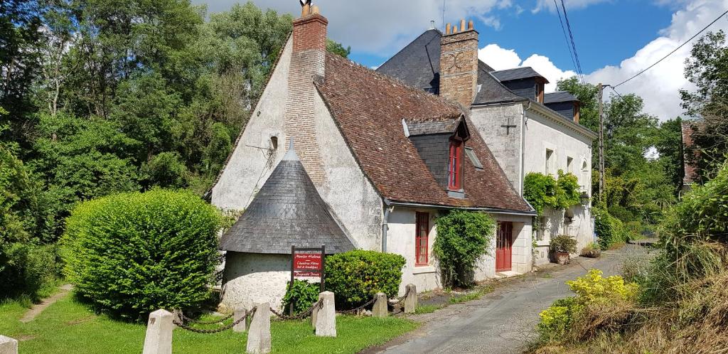 リュイーヌにあるLe Moulin Hodouxの通り上の赤い襖のある古い石造りの家