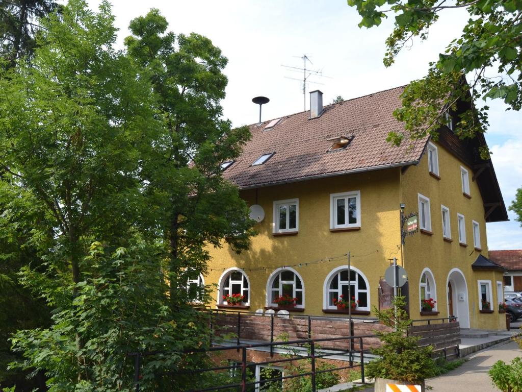 ein gelbes Haus mit braunem Dach in der Unterkunft Kraichgauer Haus in Oberreute