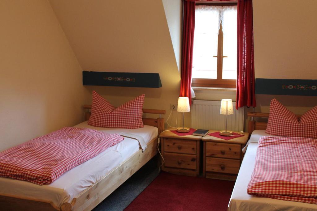 two beds in a small room with a window at Gasthof Butz in Rothenburg ob der Tauber