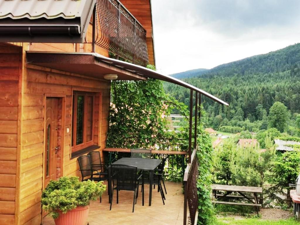 a balcony of a house with a table and chairs at Jeleni Skok in Cisna