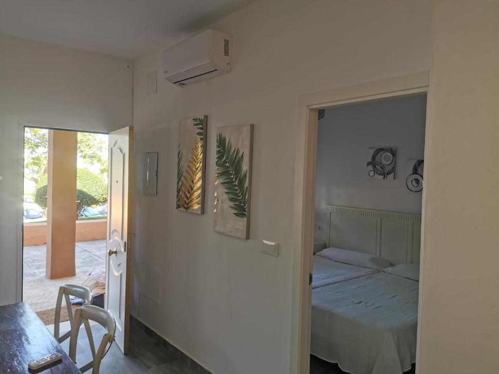 Schlafzimmer mit einem Bett und einem Wandspiegel in der Unterkunft Apartamentos Sanlúcar Beach 4 y 5 in Sanlúcar de Barrameda