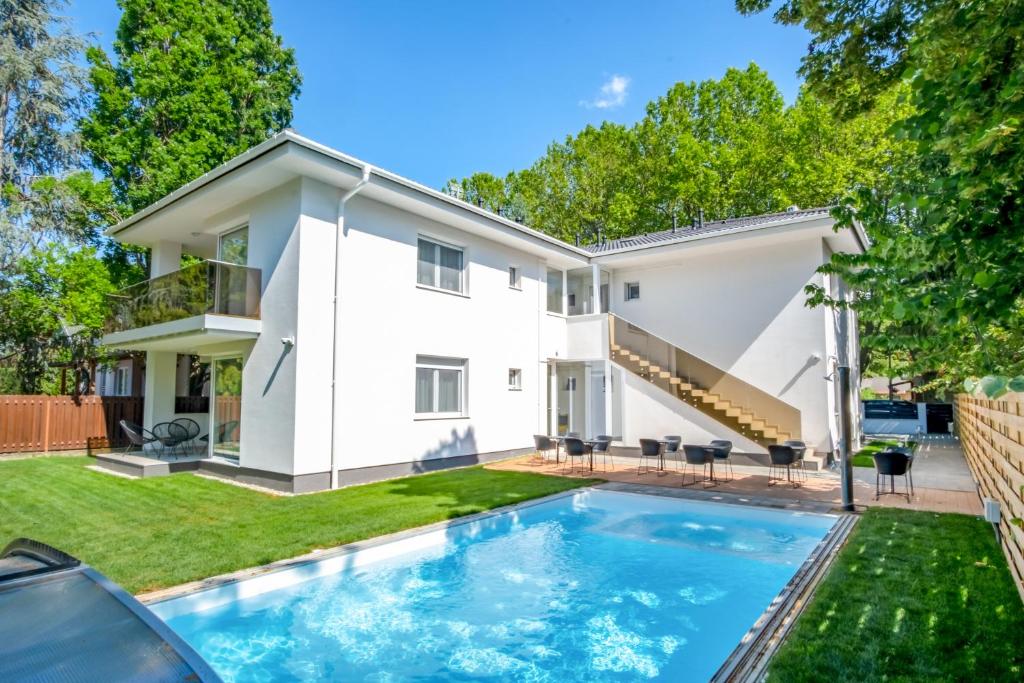 a home with a swimming pool in front of a house at MF Batthyány Premium Residence in Siófok