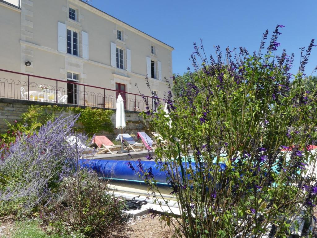 a swimming pool in front of a building at Les Jardins de Xanton in Xanton-Chassenon