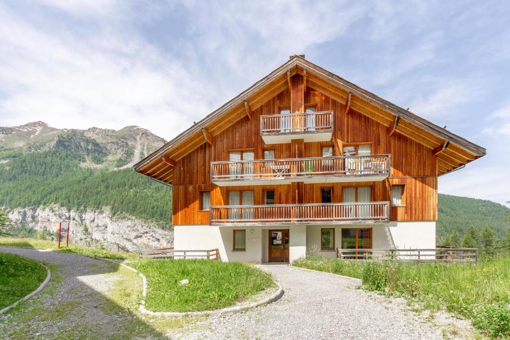 a wooden house with a balcony on a mountain at L'Oural in Les Orres