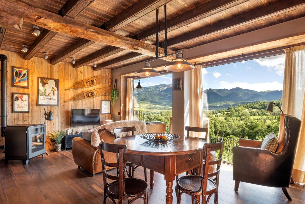 a dining room with a table and a large window at Cal Cassi - Suite de muntanya in Ger