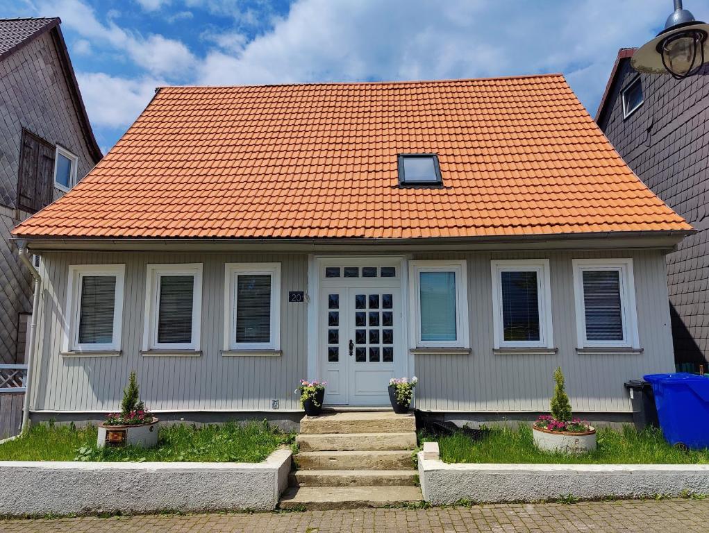 uma casa com telhado laranja e telhado laranja em Neues schönes Ferienhaus mit großer Grillterrasse für 12 Personen im Harz em Sankt Andreasberg