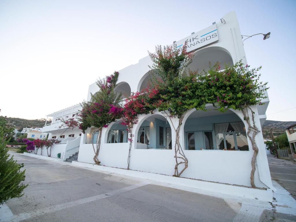 un edificio blanco con flores a un lado en Karanasos, en Batsi