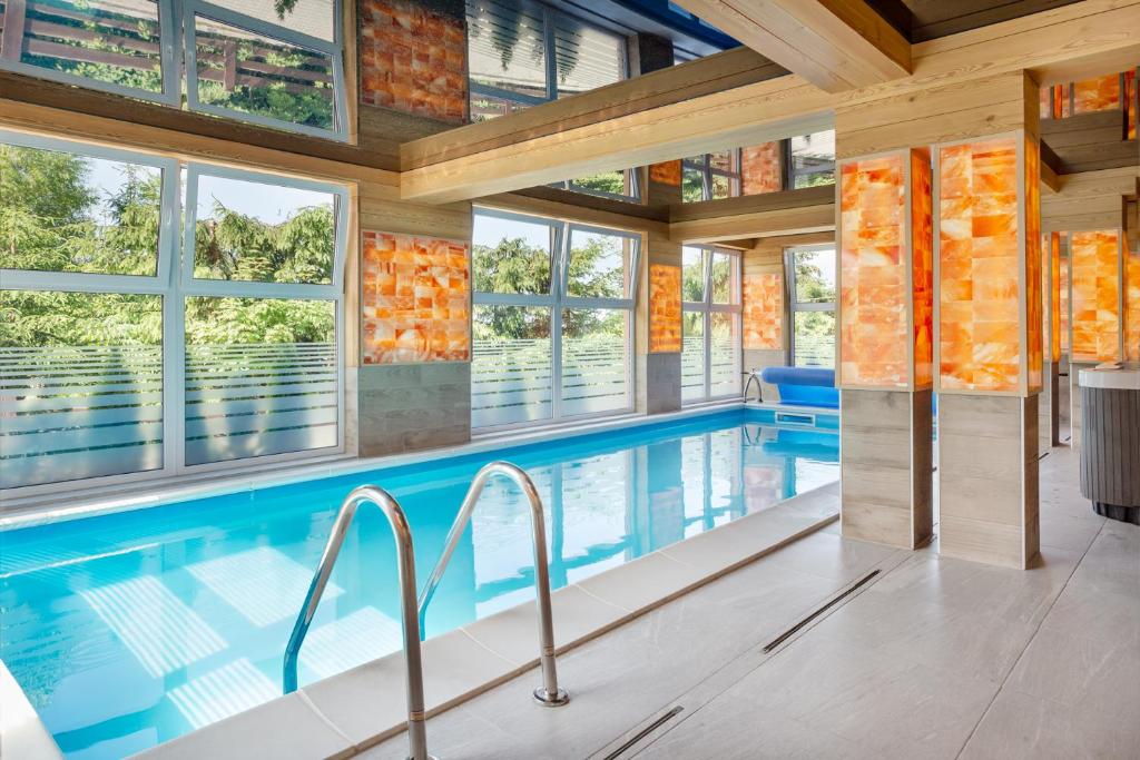 an indoor pool in a house with windows at Osrodek Wypoczynkowy Lesniczówka & Elias SPA in Istebna