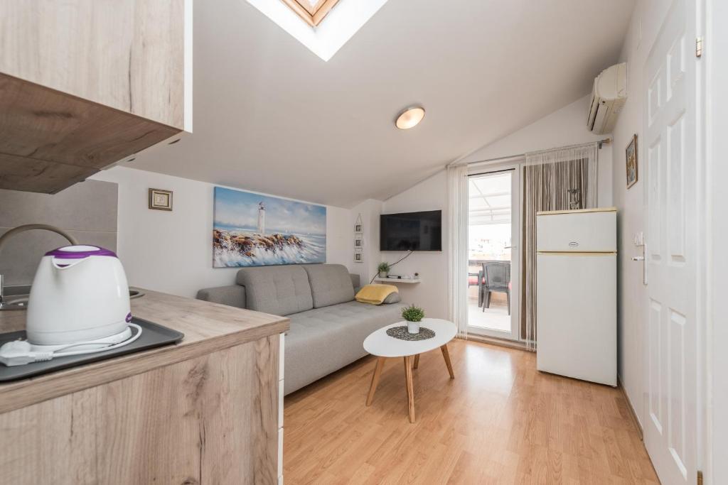 eine Küche und ein Wohnzimmer mit Sofa und Tisch in der Unterkunft Ilia sea view apartment in Novalja