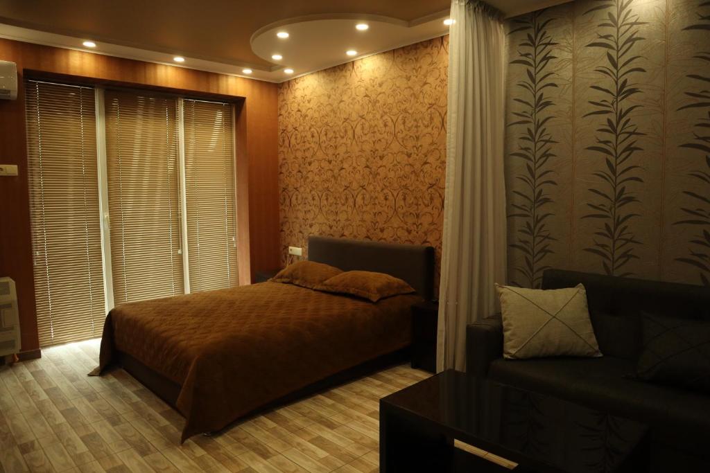 a bedroom with a bed and a couch at Comfort Lux in Tbilisi City
