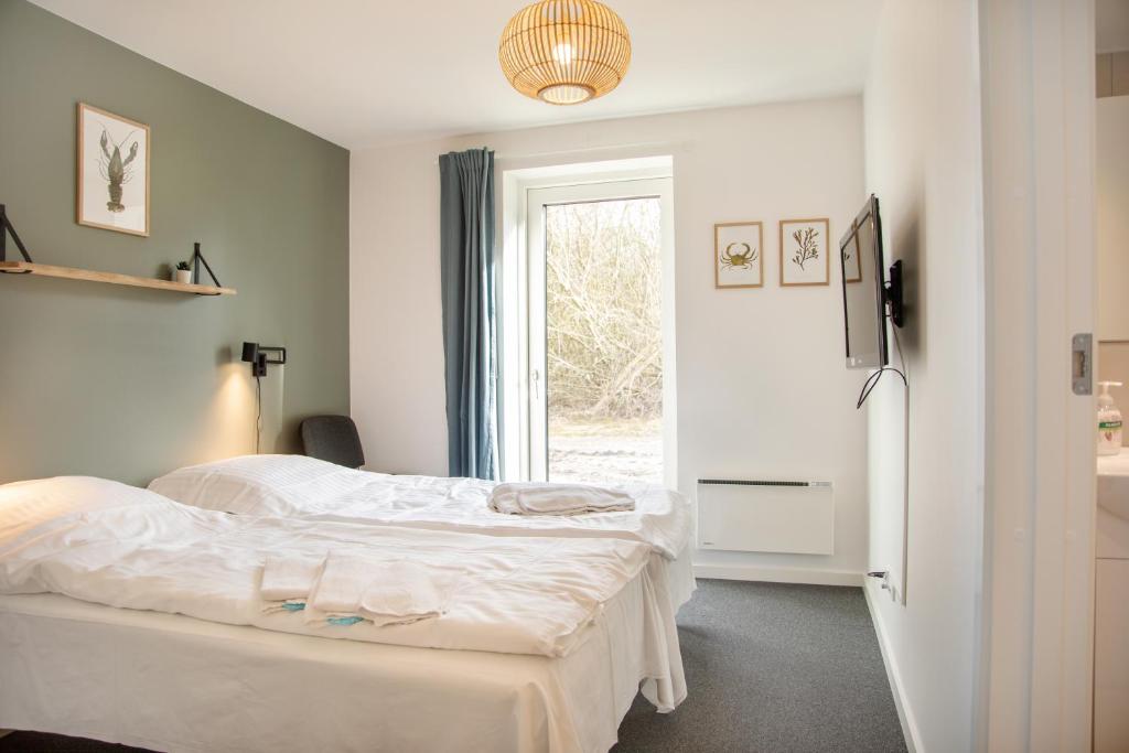 een slaapkamer met 2 bedden en een raam bij Feriebyens Bed & Breakfast in Rødvig
