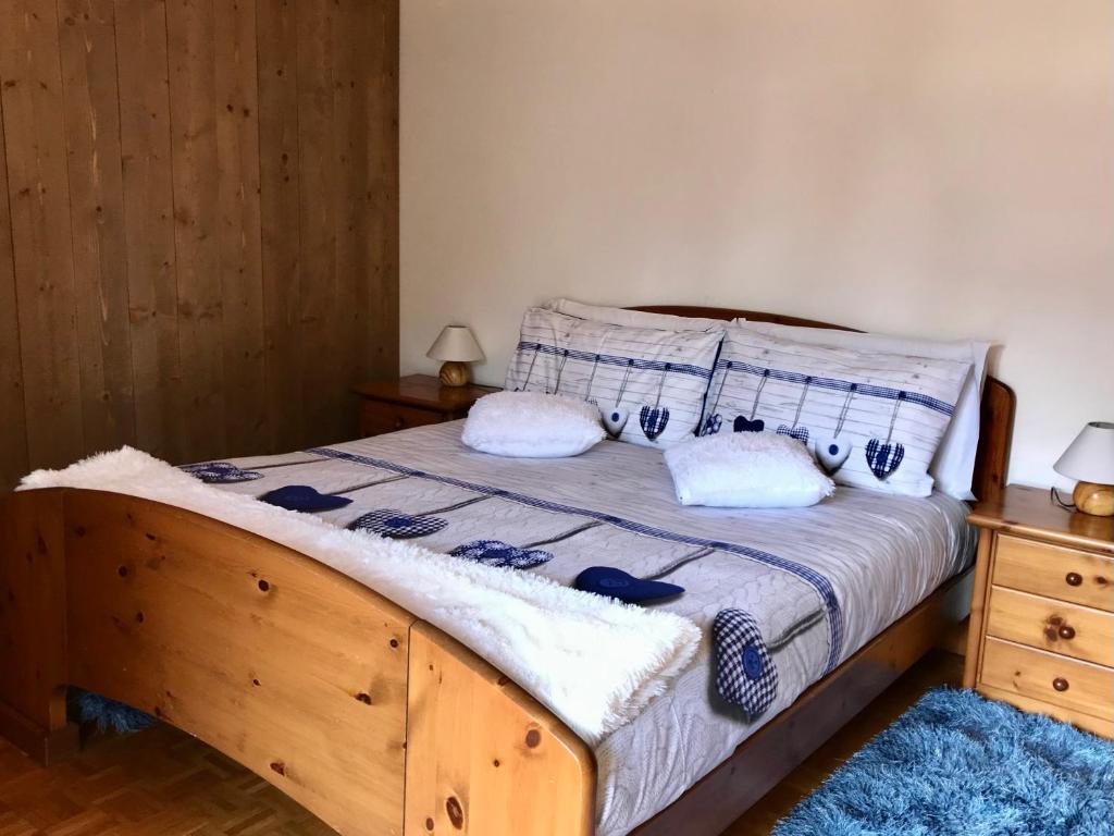 a bedroom with a wooden bed with two pillows at Chalet Bormino in Bormio