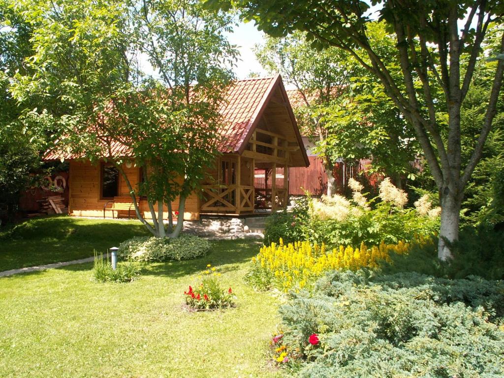 um chalé de madeira com um jardim em frente em Marina Bajana em Mikolajki