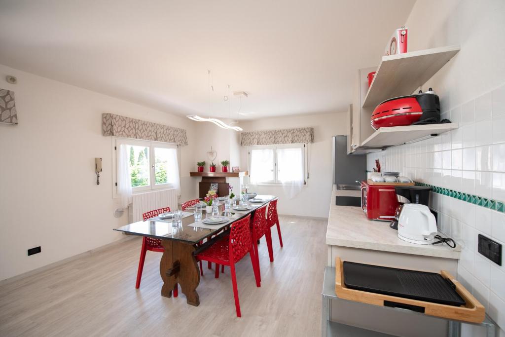 una cocina con una mesa con sillas rojas. en Il Cortiletto - Appartamento Lores, en Manerba del Garda