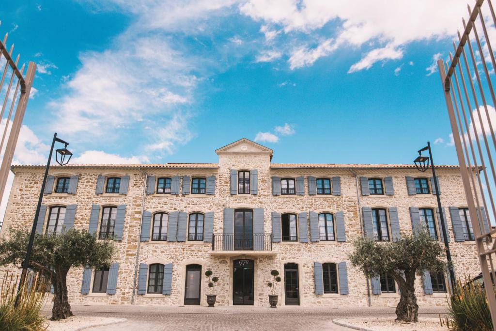 a large stone building with a blue sky in the background at Hôtel 1770 &amp; Spa in Le Pontet