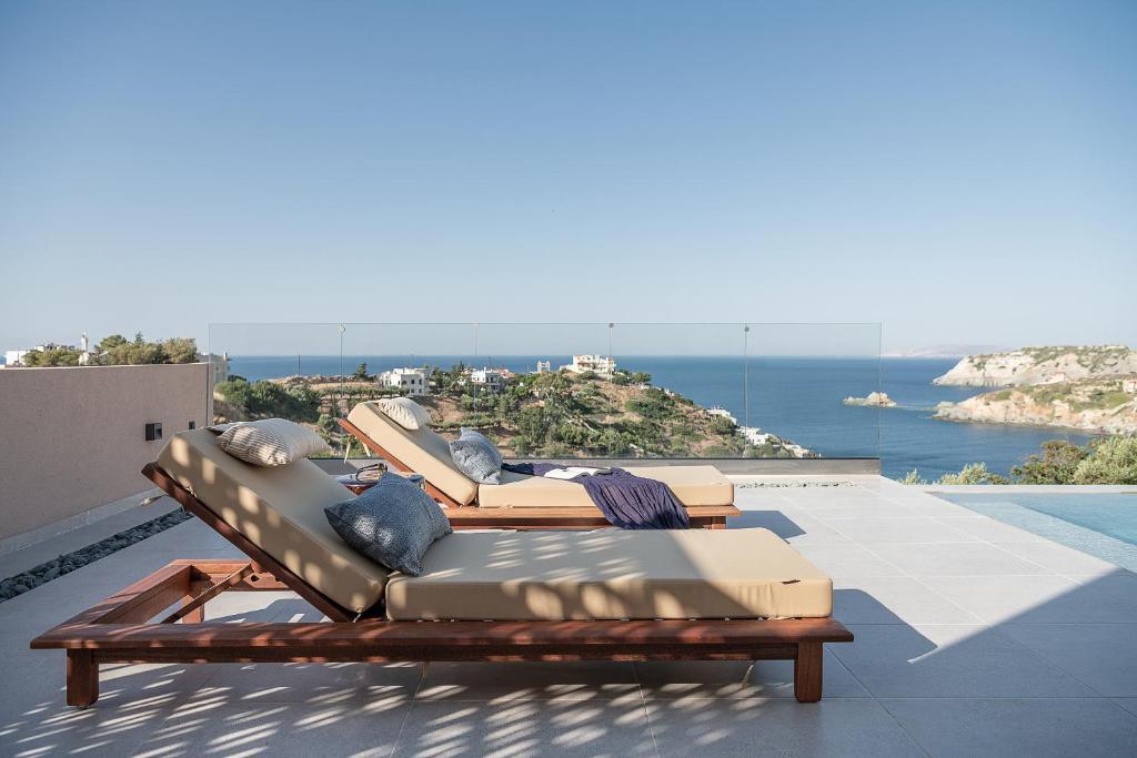 Duas espreguiçadeiras sentadas no topo de um telhado em Luxurious new villa Kokomo Gaia w/ Private Pool, 400m to beach em Ligaria