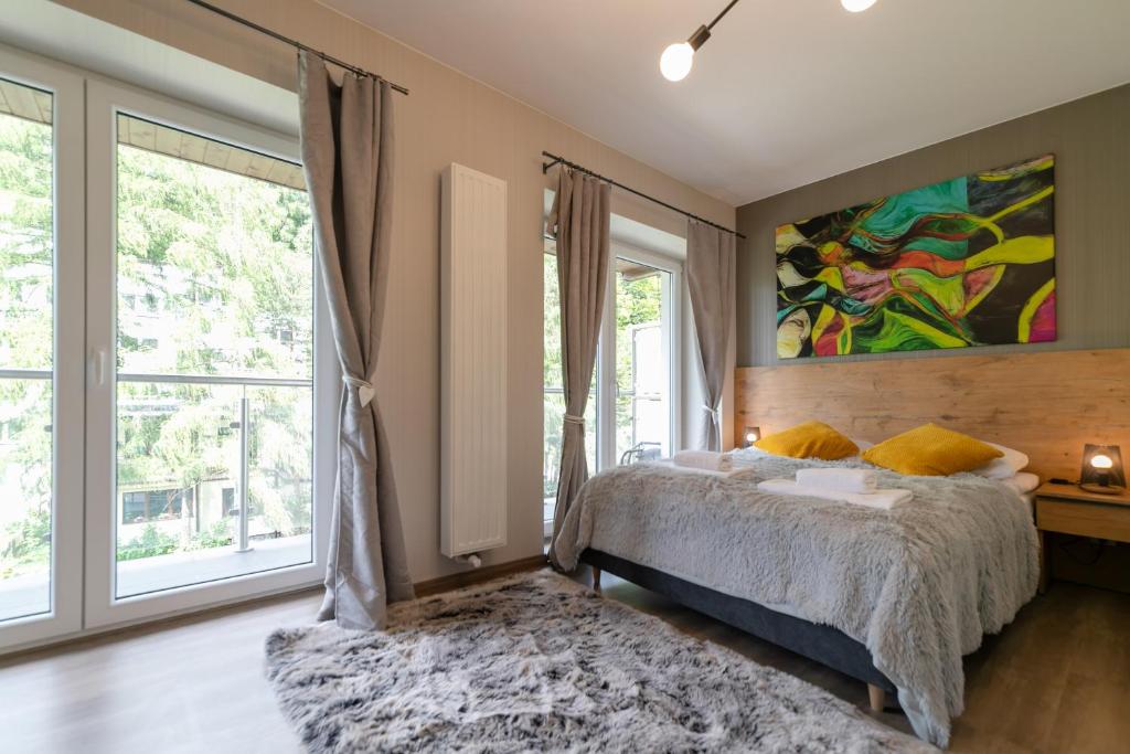 a bedroom with a bed and a large window at Kurort Kozubnik Daglezja - Apartamenty Dream Apart in Porąbka