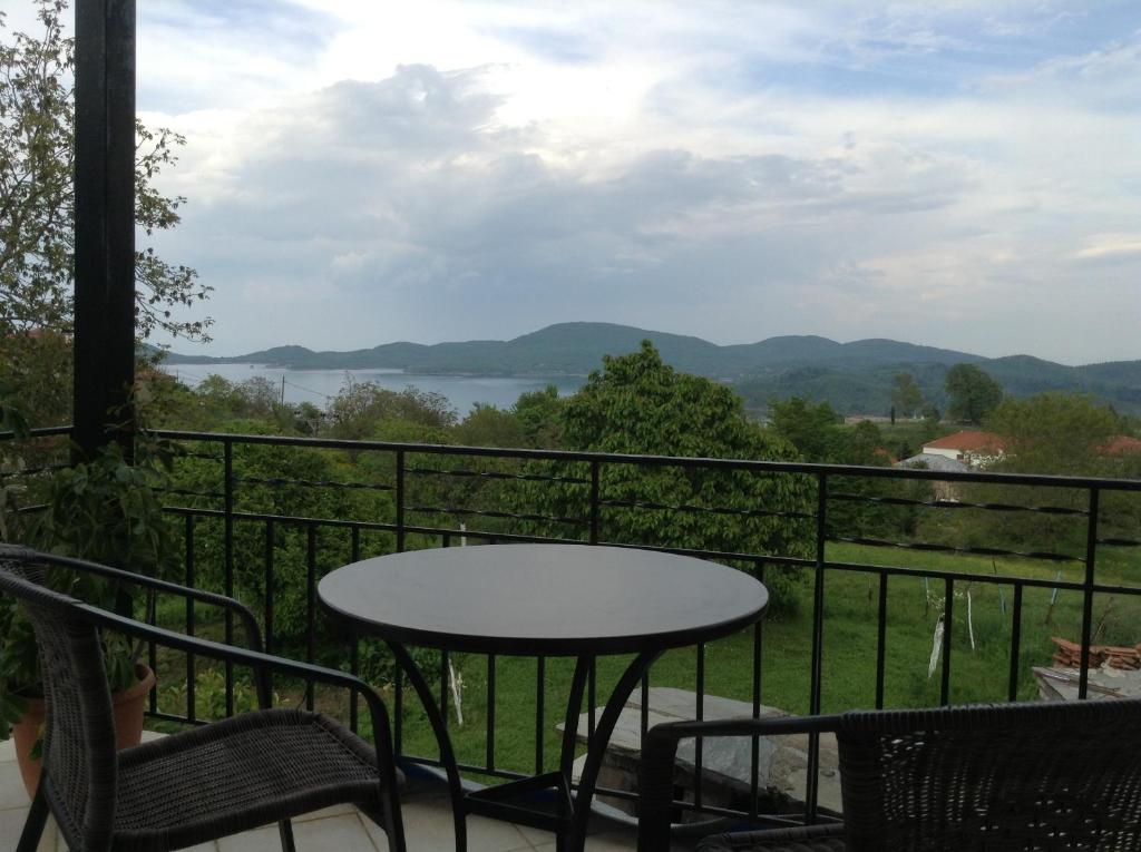 a table and chairs on a balcony with a view at Guesthouse Lamprini in Neochori