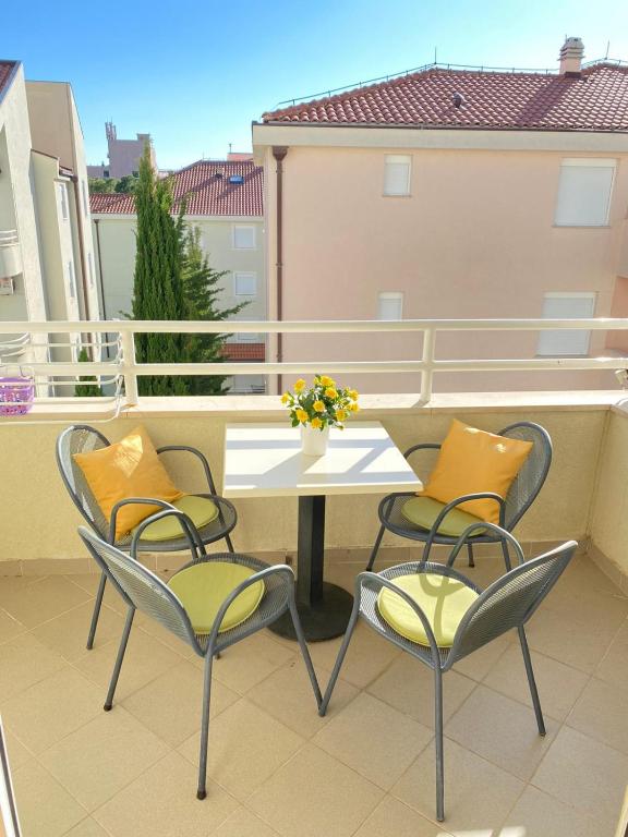 a table and four chairs on a balcony at Apartment Meri Baska Voda in Baška Voda