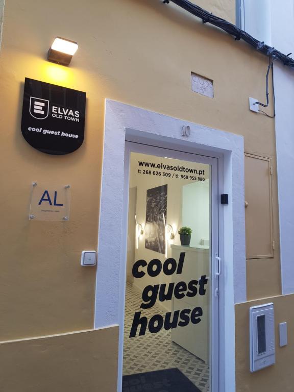 una puerta a una casa de huéspedes con un cartel en Cool Guest House, en Elvas