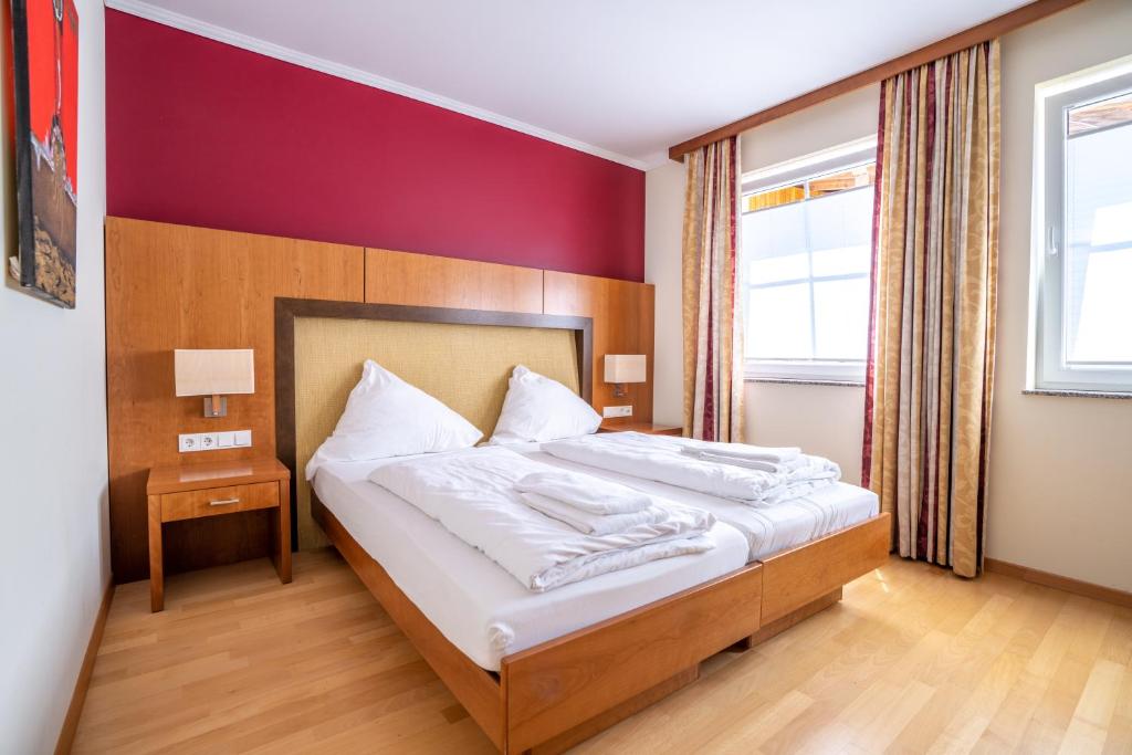 a bedroom with a large bed with white sheets at Mühlengarten by Relax Inn - Staffless & Self Check-In in Nittel