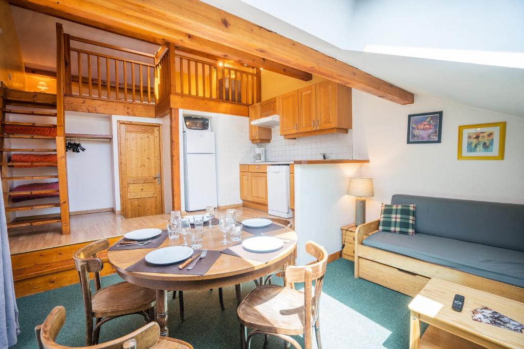 a kitchen and dining room with a table and a couch at cellier 8 appart 5 personnes les 2 alpes in Les Deux Alpes