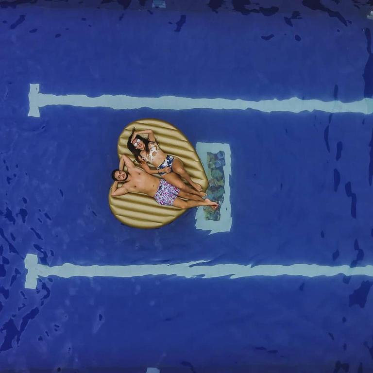 a painting of a woman laying on a towel in the water at Hotel Boutique Budapez in Honda