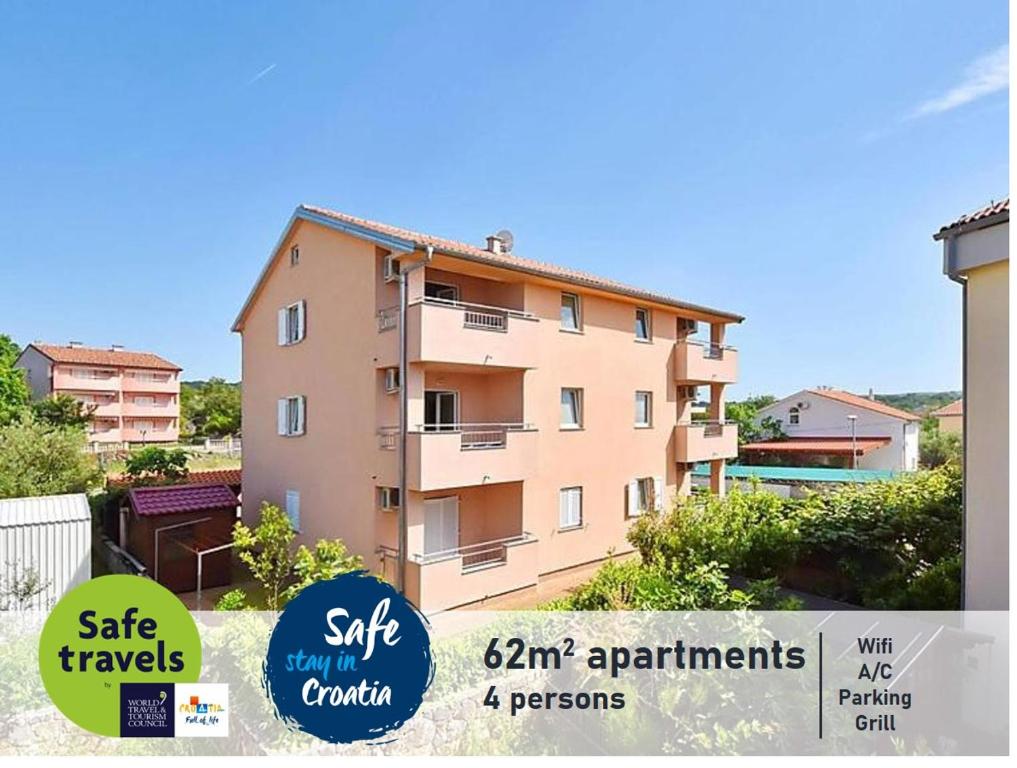 a apartment building with signs in front of it at Apartments Dunja Malinska in Malinska