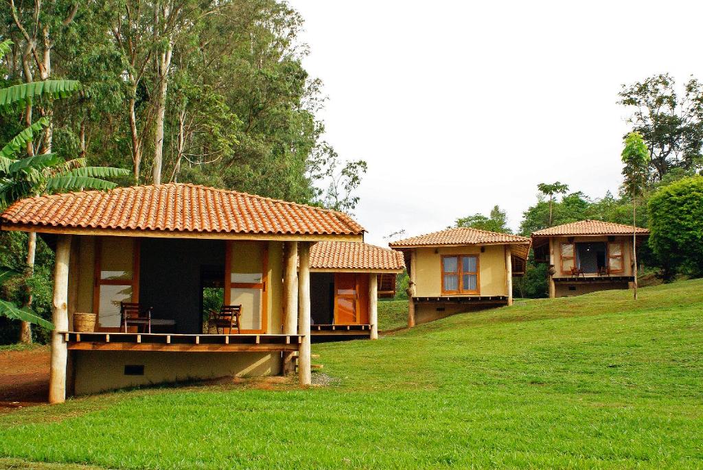 a row of cottages in a grassy field at Porto Fazenda Hotel in Alfenas