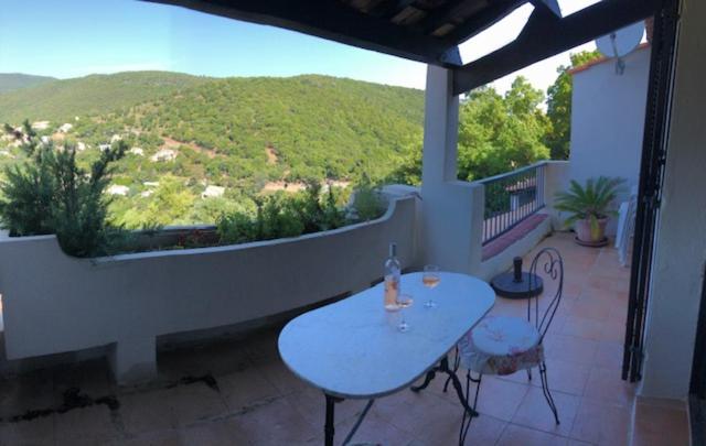 patio con mesa y sillas en el balcón en T2 terrasse spacieuse belle vue résidence avec piscine, en La Croix-Valmer