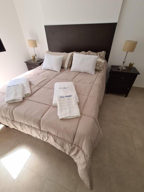 een slaapkamer met een groot bed en 2 handdoeken bij DOS ANGELES in Salta