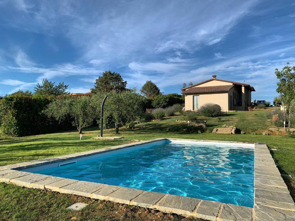 聖薩維諾山的住宿－Nonno Gino suite，一座带房子的庭院中的蓝色游泳池