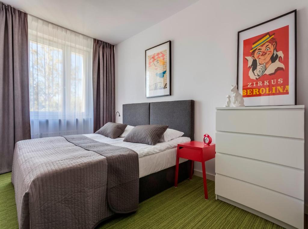een slaapkamer met een bed en een rode tafel bij B&B Julinek Park in Leszno