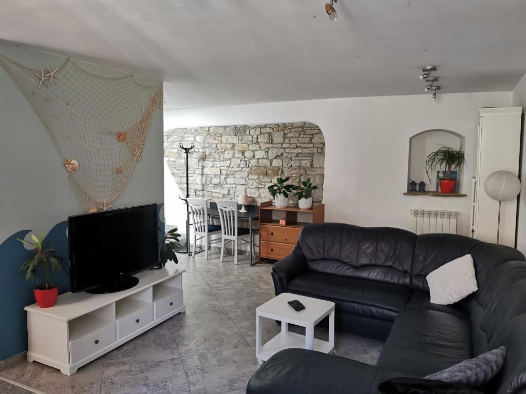 a living room with a couch and a tv at Apartment Terassin in Koper
