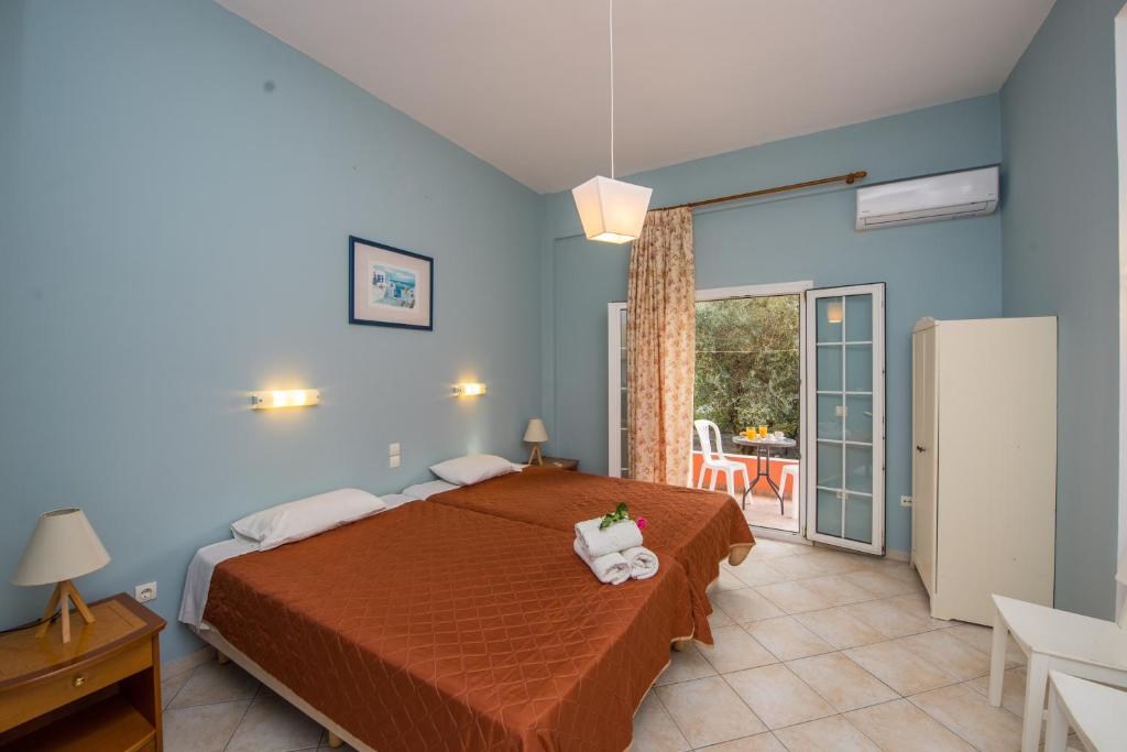 a bedroom with a bed and a table and a refrigerator at Kogeros in Agios Georgios Pagon