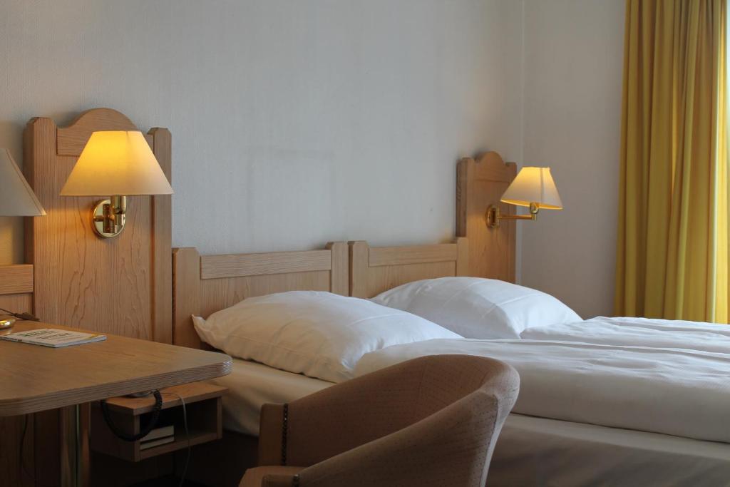 a hotel room with two beds and a desk at Hotel Gasthof zur Linde in Rothenburg ob der Tauber