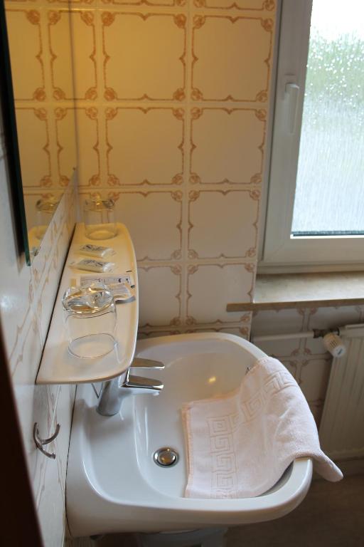 a bathroom with a white sink and a mirror at Hotel Gasthof zur Linde in Rothenburg ob der Tauber