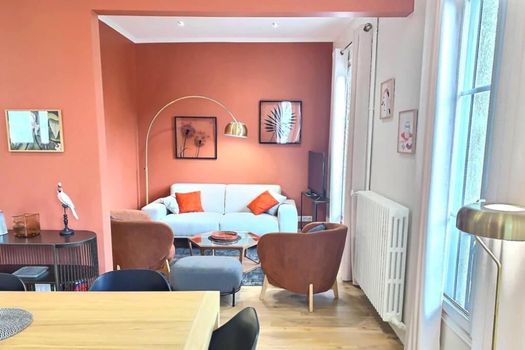 - un salon avec un canapé blanc et des murs orange dans l'établissement CENTRE-VILLE CATHEDRALE ET PARKING GRATUIT, à Reims
