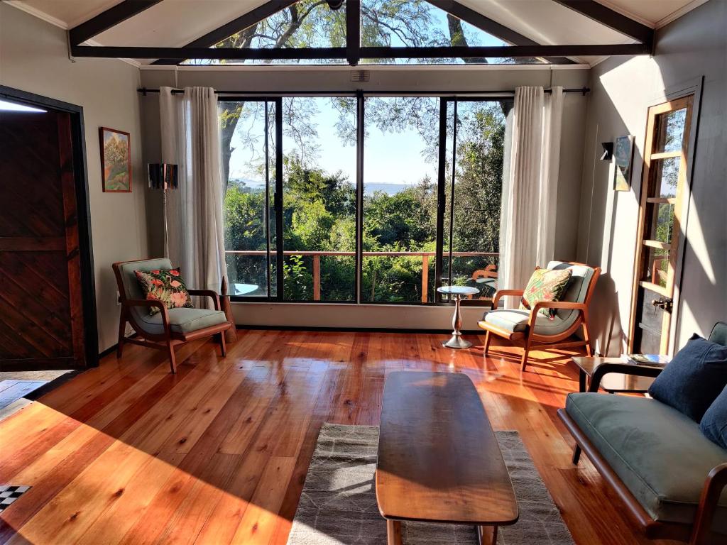 a living room with a table and a large window at Karkloof Hideout in Howick